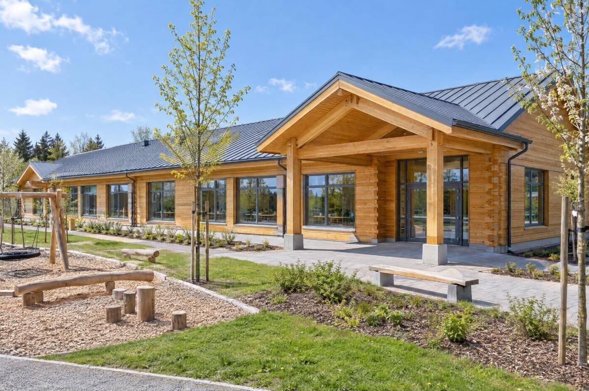 Single-storey glulam school building with timber entrance canopy